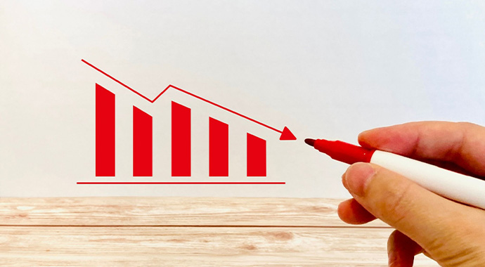 下落するグラフを指し示すイメージ画像